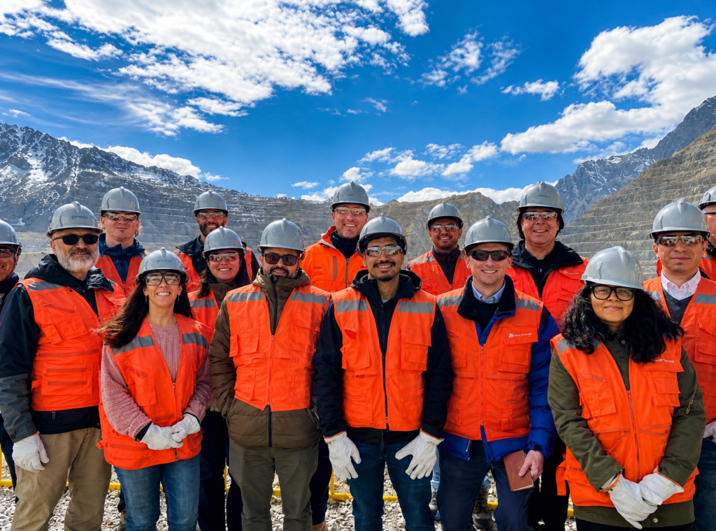 Equipo de trabajadores de la minería en terreno, con cascos y chalecos reflectantes, en faena de alta montaña en Chile