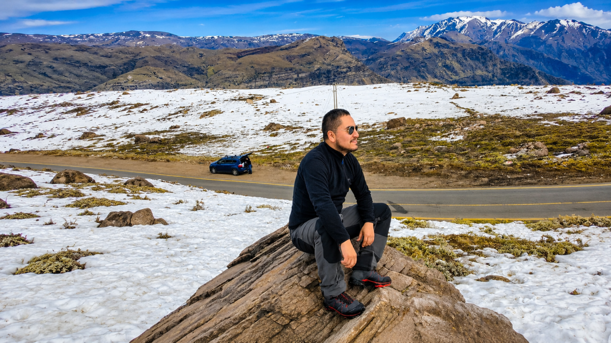 Patricio Pereira, Geólogo Senior, observando el paisaje cordillerano durante una campaña de exploración minera en Chile.